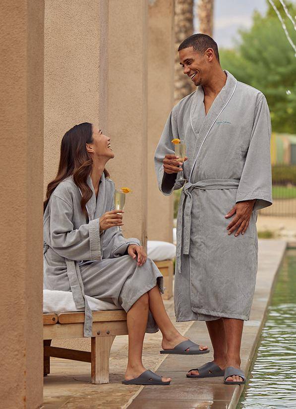 a man and woman in bathrobes by a pool